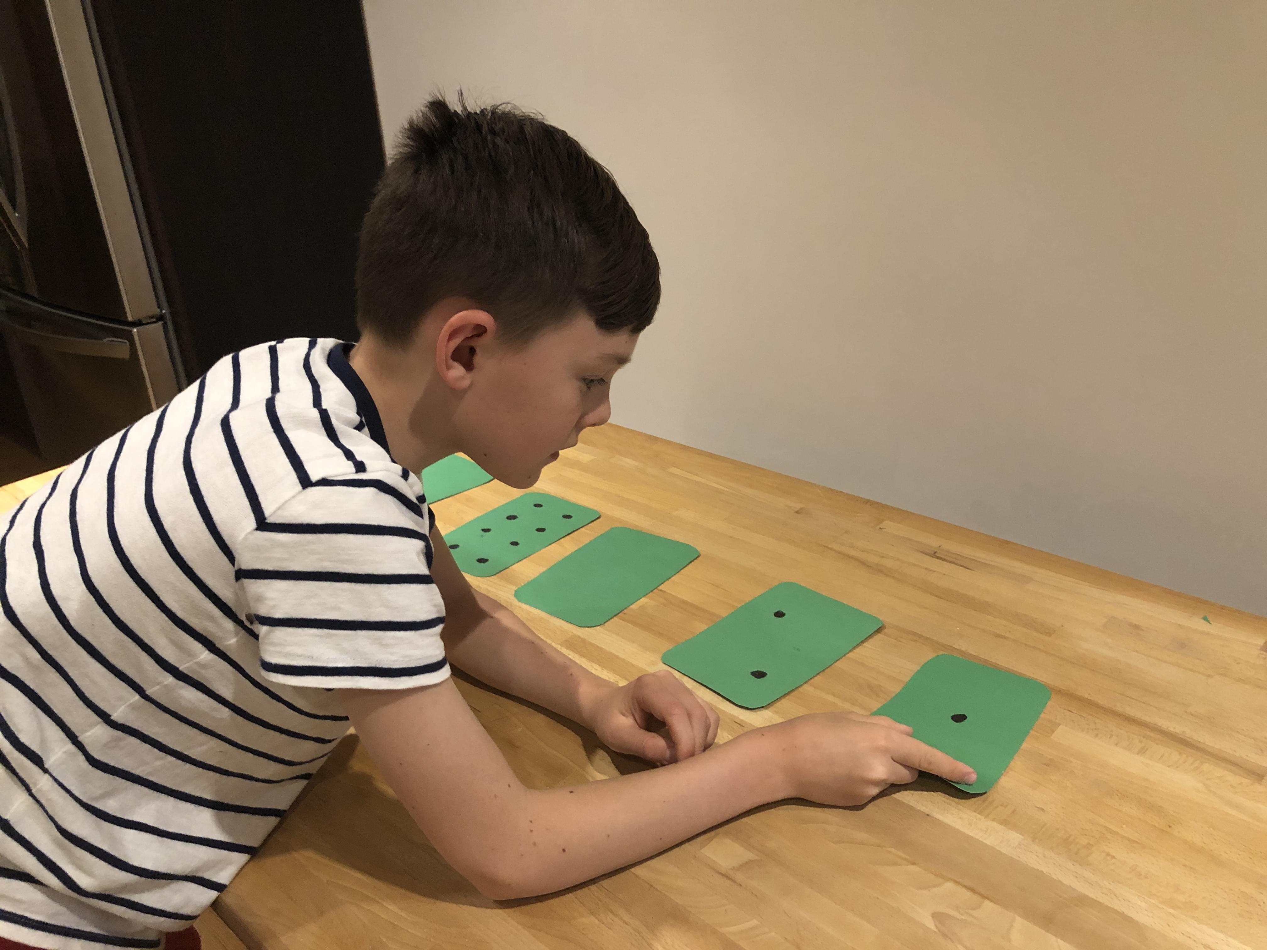 Child flipping the cards so that eleven dots are showing.