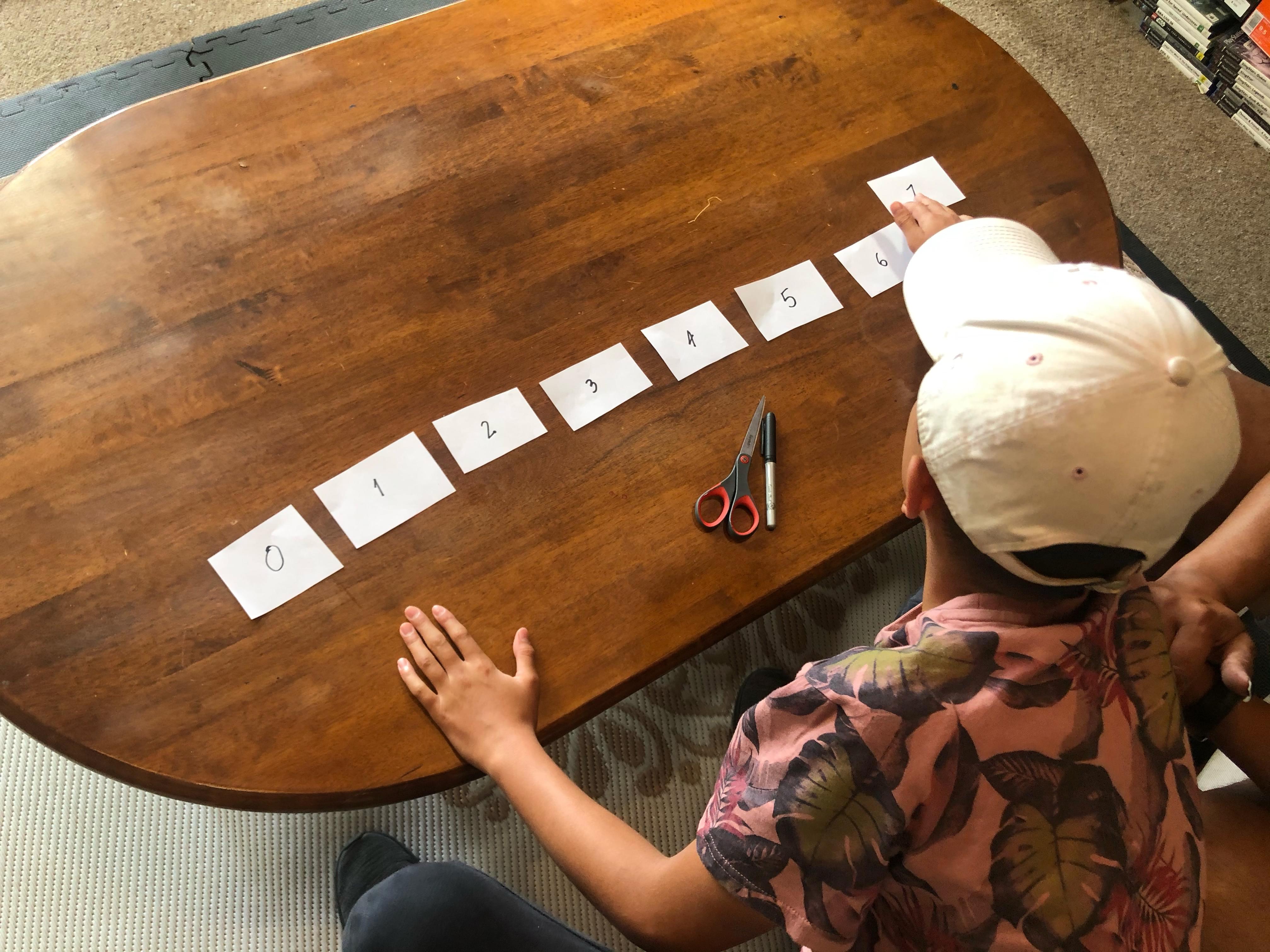 Child placing the 8 cards in order from lowest to highest.