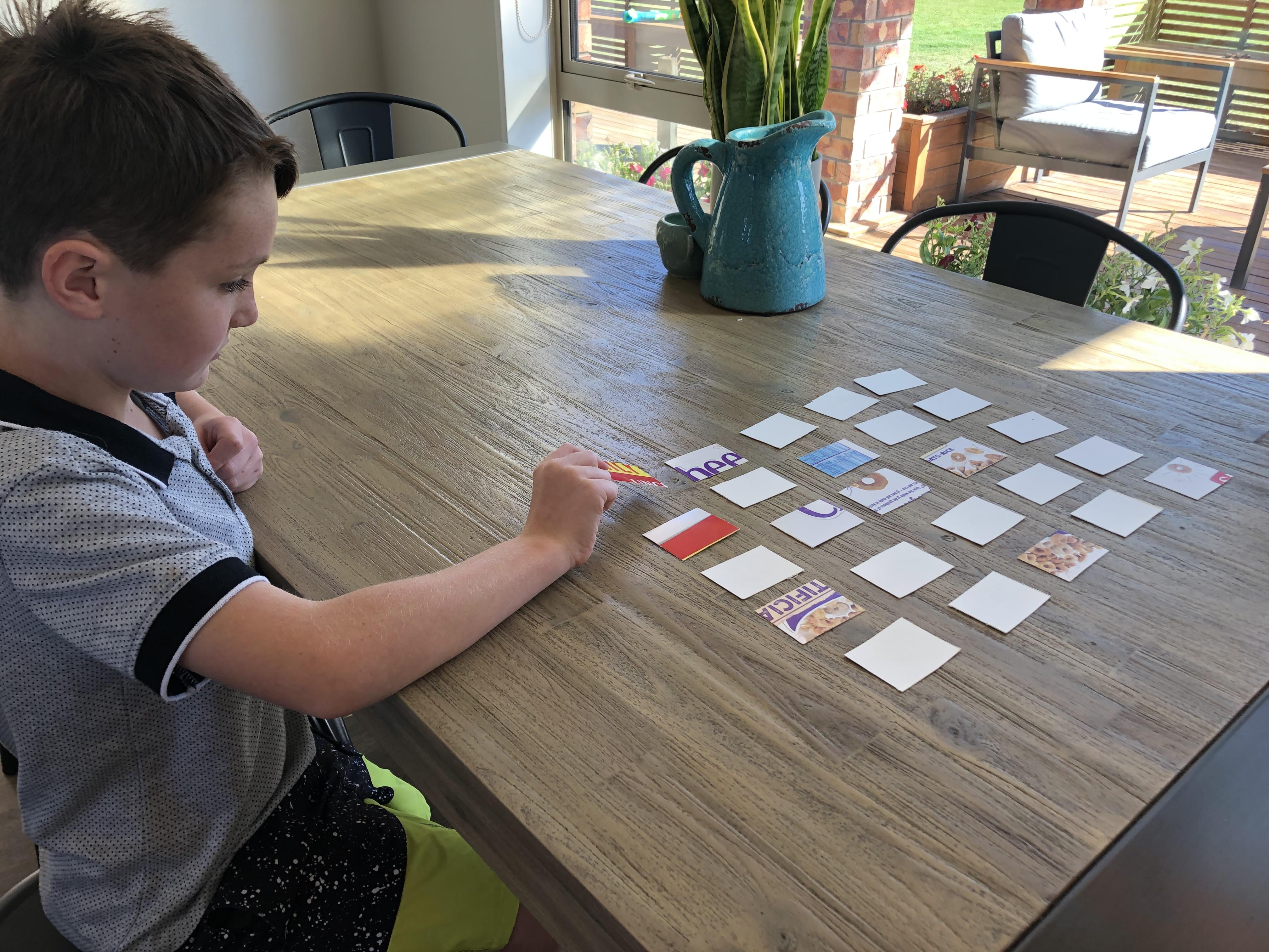 Child placing cards in a five by five grid.