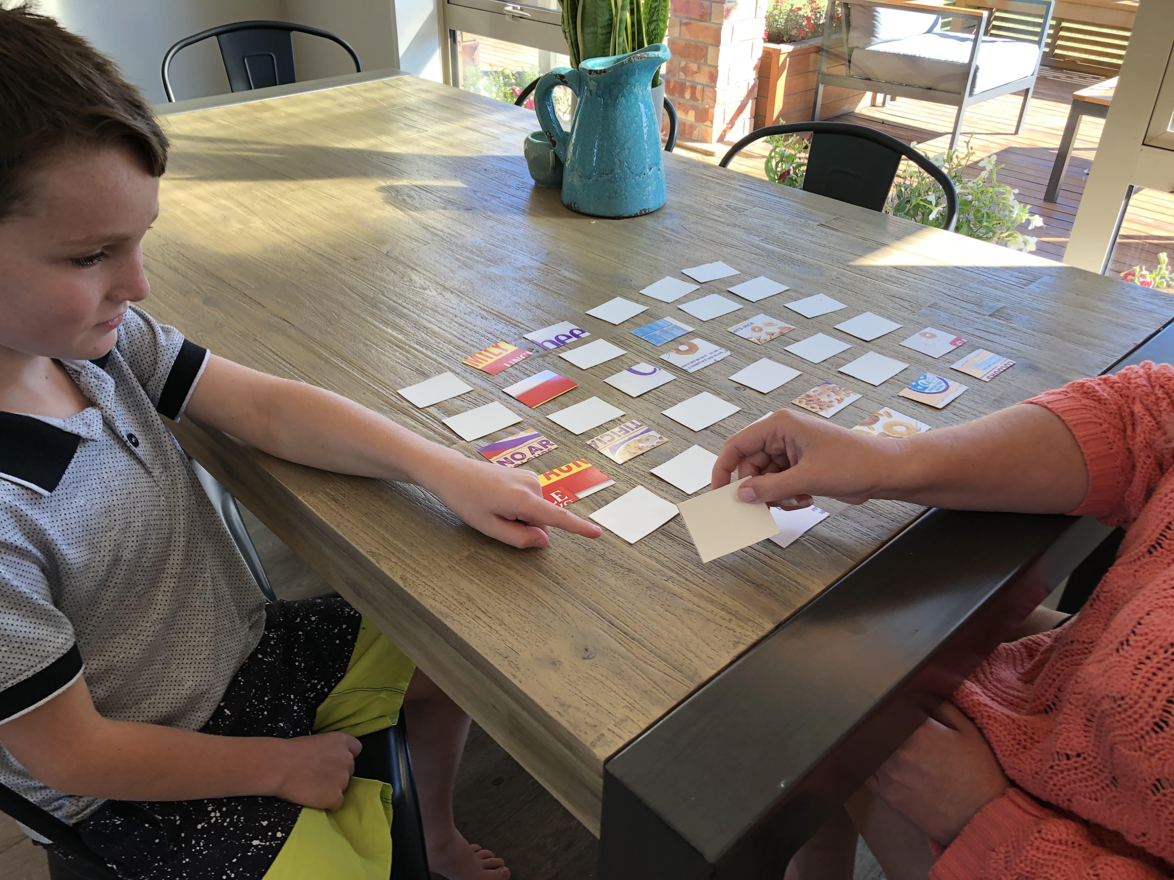 Adult adding another row and column of cards to the grid.