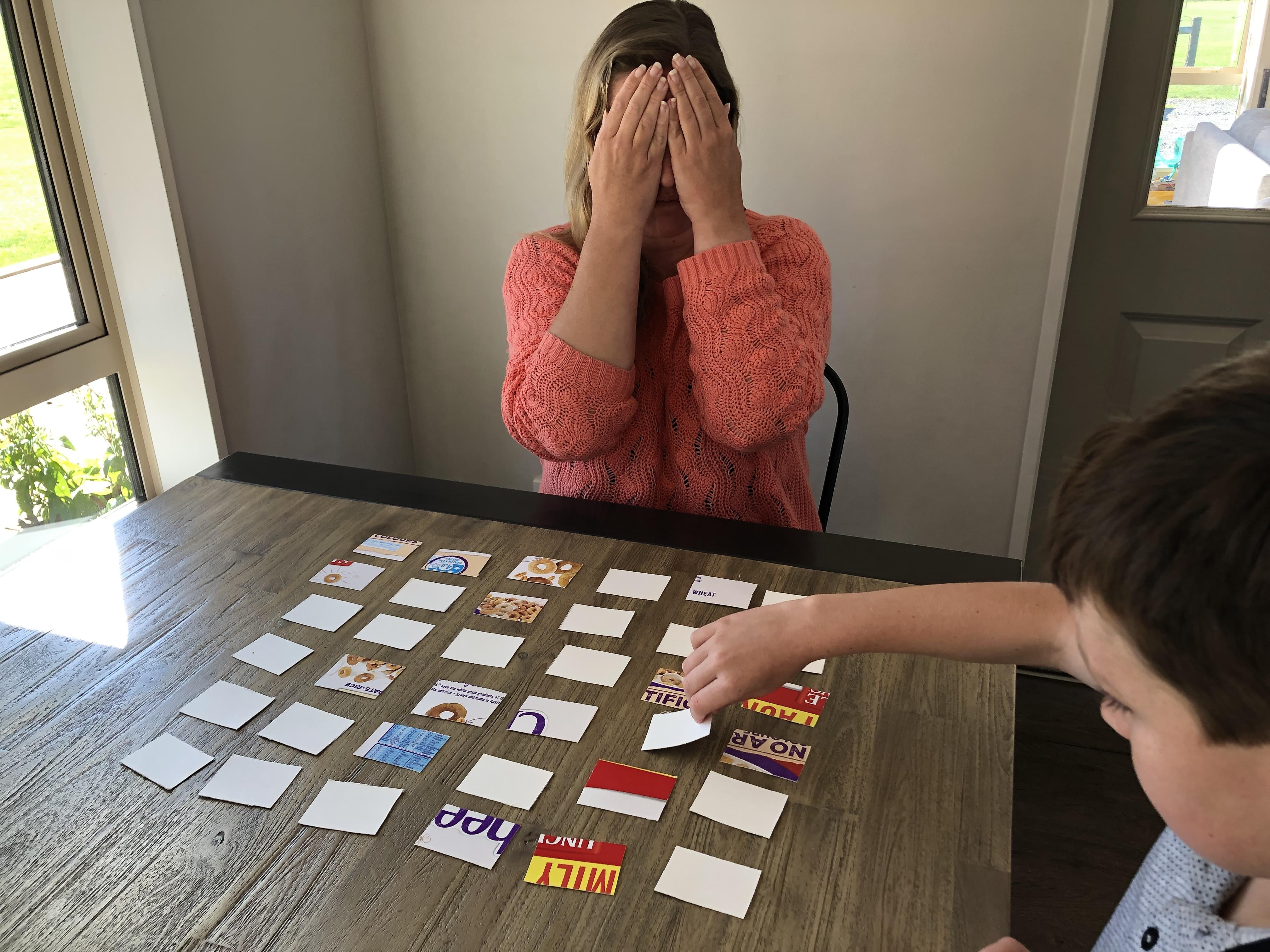 Adult closes eyes while the child flips over one of the cards.
